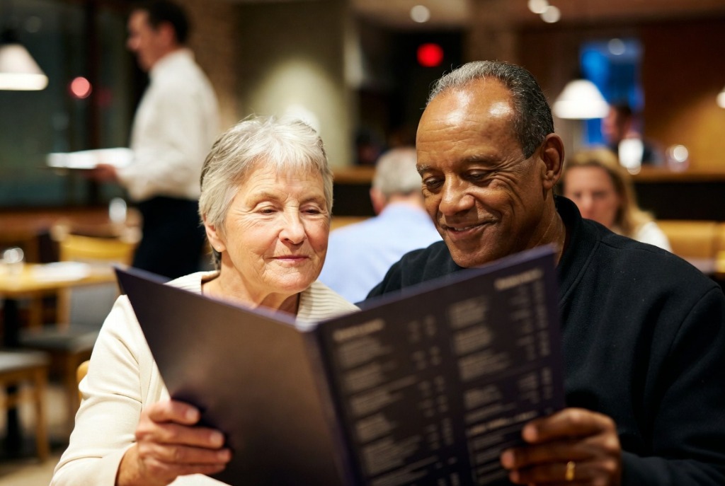 Couple senior au restaurant lisant un menu